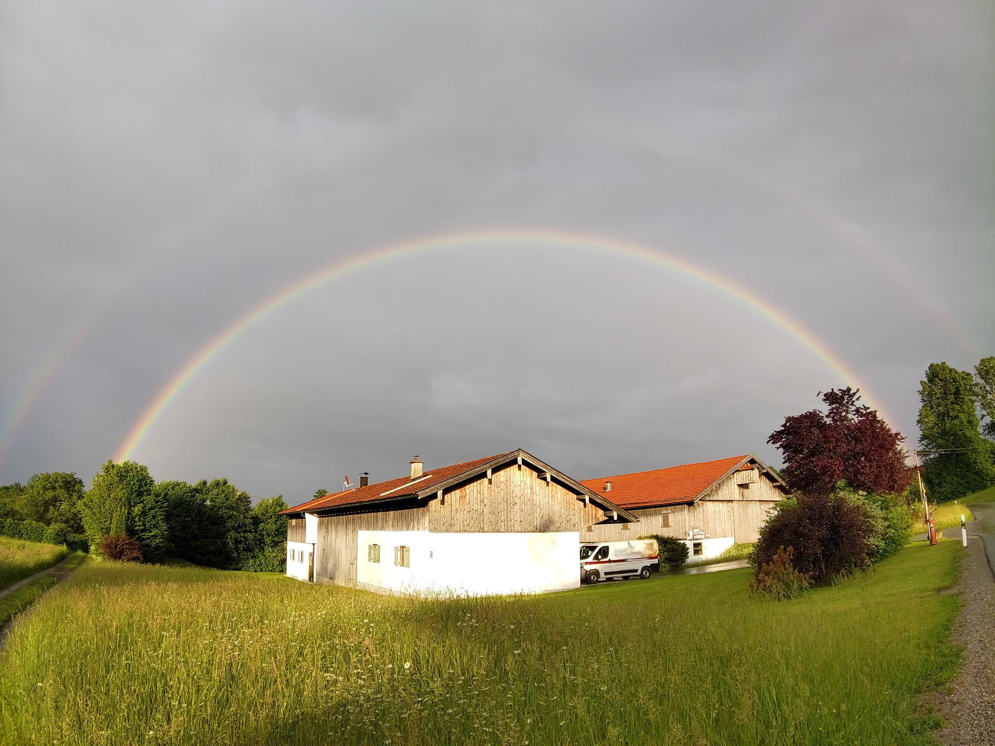 A double rainbow behind a bavarian house